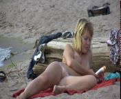 Голая блондинка расставила ноги и загорает на пляже